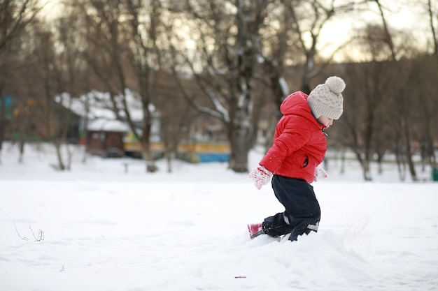 Les enfants jouent dehors en hiver. Jeux de neige dans la rue.