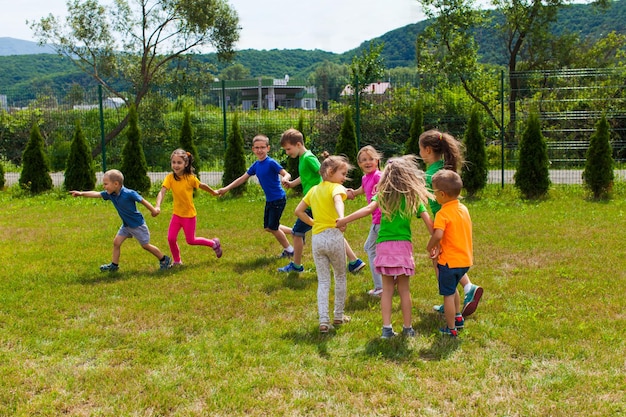 Les enfants jouent dehors. Jeu de train - les enfants se tiennent la main comme un wagon de chemin de fer et courent. Le premier garçon choisit le chemin, activité sportive