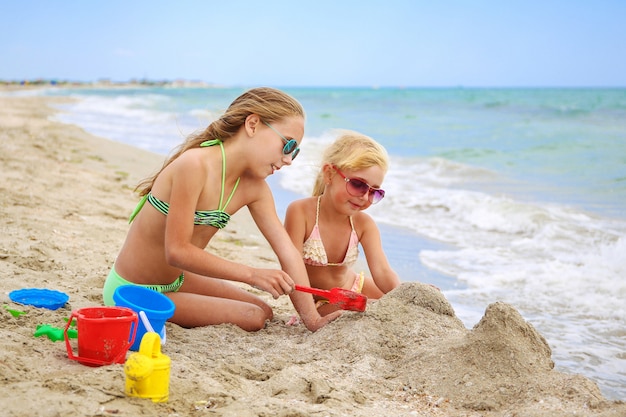 Les enfants jouent avec du sable sur la plage.