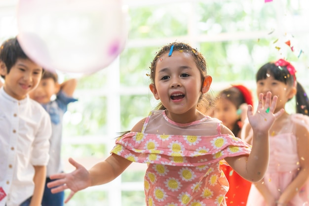 Les enfants jouent et jettent du papier à la fête des enfants