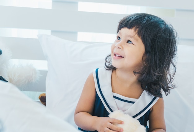 Les enfants jouent sur le lit heureux.