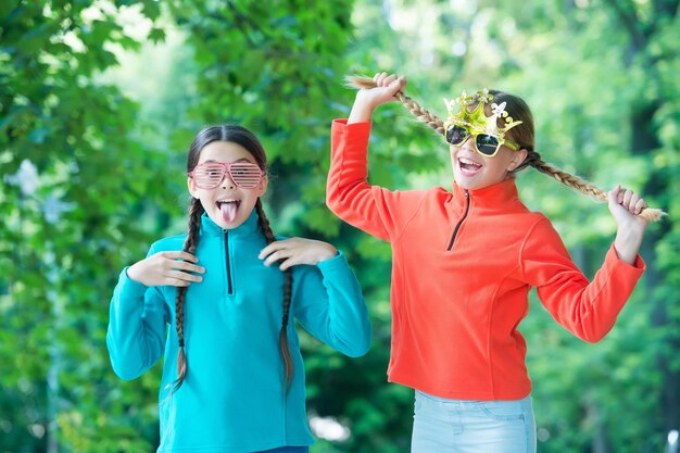 Enfants joyeux s'amusant lors d'une randonnée sur fond de nature forestière, concept de grimaces.