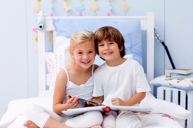 Enfants lisant un livre dans la chambre