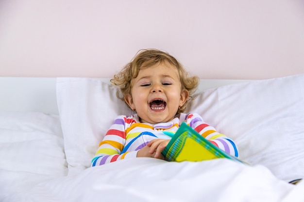 Les enfants lisent un livre au lit Mise au point sélective