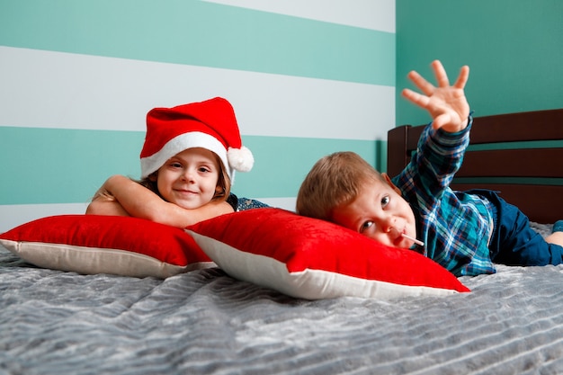 Les enfants sur le lit sont habillés pour la nouvelle année