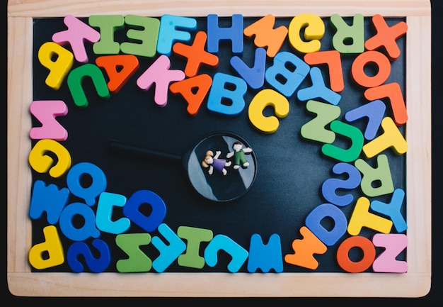 Photo enfants sur loupe et lettres colorées de l'alphabet