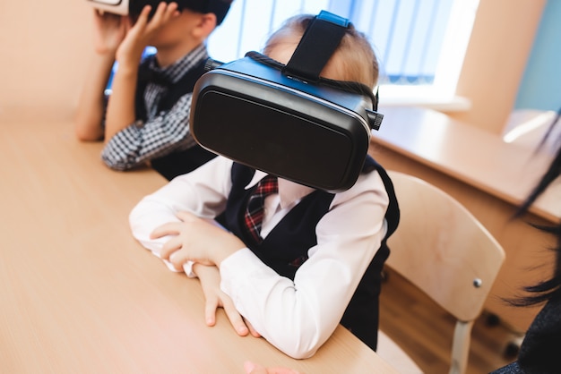 Les enfants avec des lunettes de réalité virtuelle sont au bureau de l'école