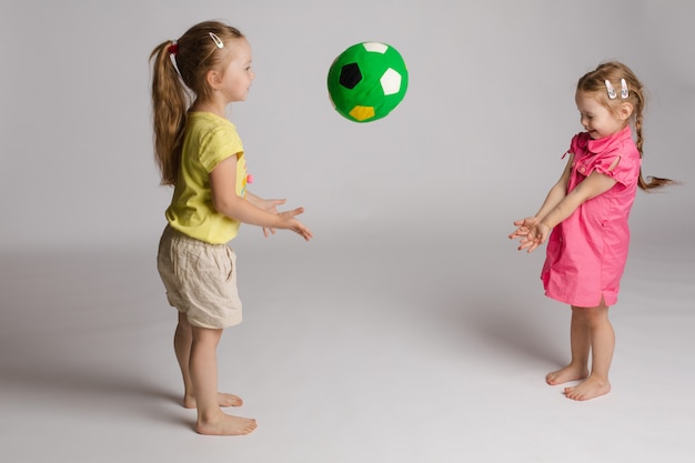 Enfants malicieux lancer et attraper la balle. Concept de bonheur et de jeu.