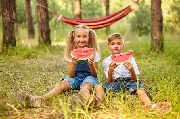 Enfants mangeant de la pastèque dans le parc