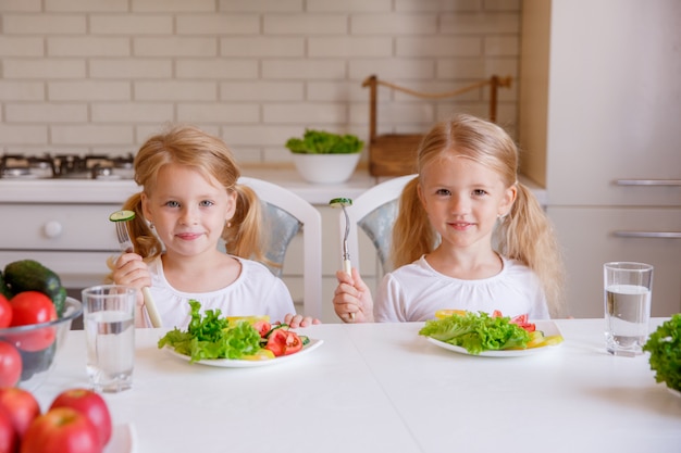 Les enfants mangent des aliments sains dans la cuisine