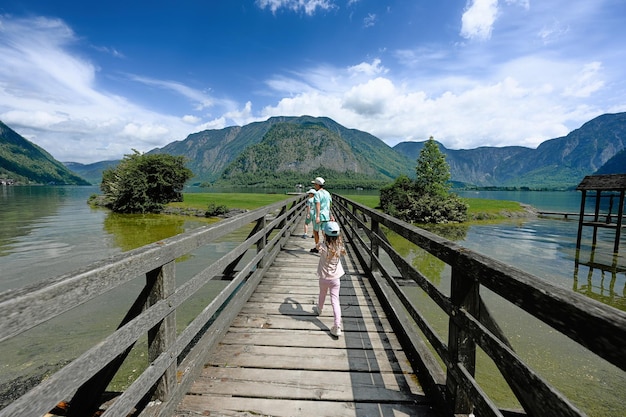 Enfants marchant dans un pont de bois sur le lac des Alpes autrichiennes à Hallstatt Salzkammergut Autriche