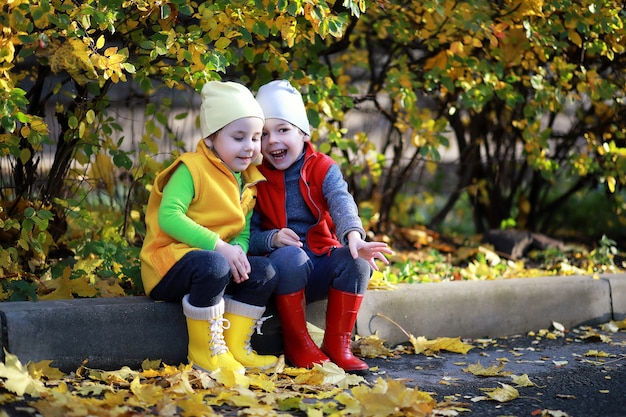 Les enfants marchent dans le parc d'automne à l'automne