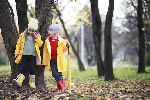 Les enfants marchent dans le parc d'automne à l'automne