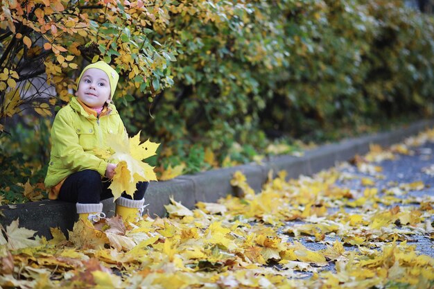 Les enfants marchent dans le parc d'automne à l'automne
