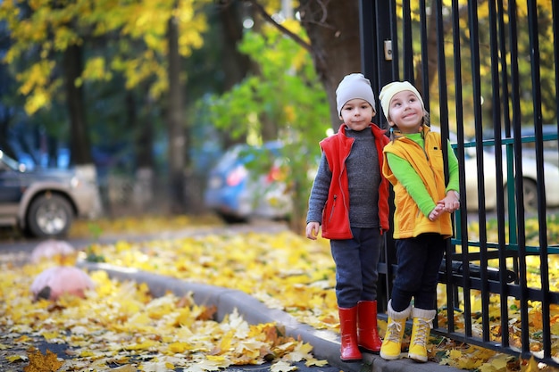 Les enfants marchent dans le parc d'automne à l'automne