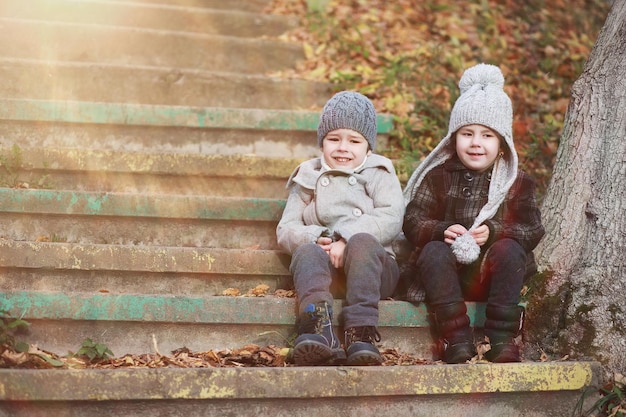 Les enfants marchent dans le parc d'automne à l'automne