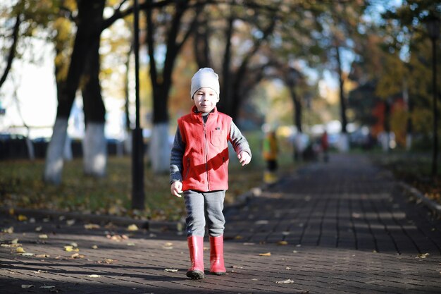 Les enfants marchent dans le parc d'automne à l'automne