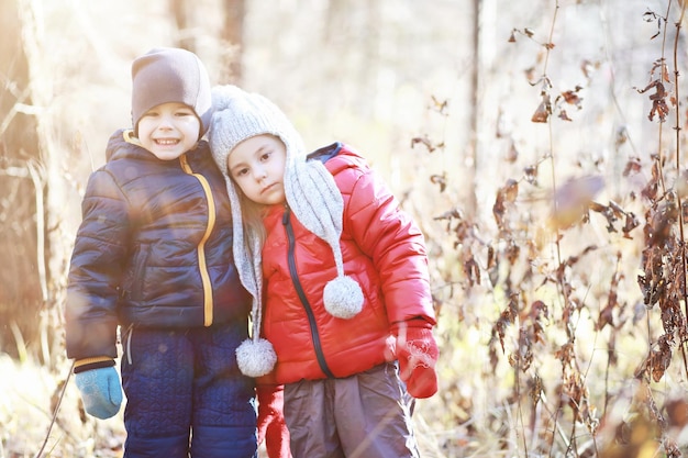 Les enfants marchent dans le parc d'automne à l'automne