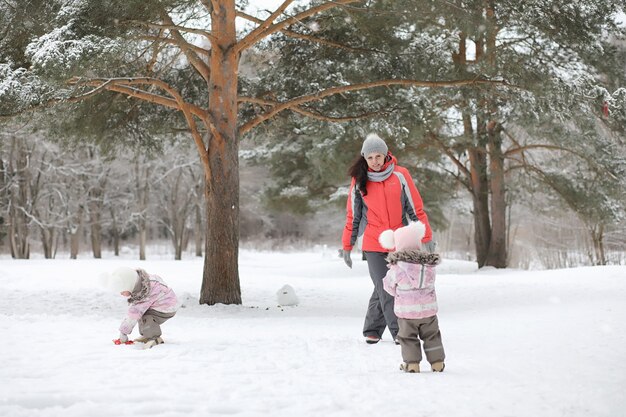 Les enfants marchent dans le parc en hiver. Famille de forêt d'hiver avec enfants en promenade. Une froide journée d'hiver est une promenade en famille.