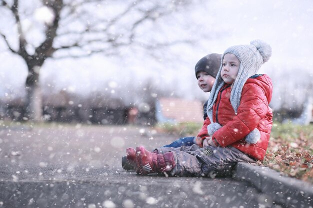 Les Enfants Marchent Dans Le Parc Avec La Première Neige