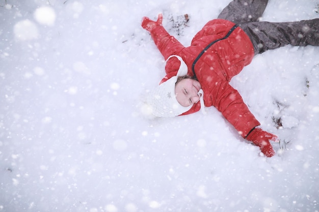 Les enfants marchent dans le parc première neige