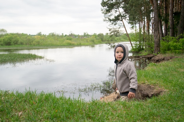 Les enfants marchent sur la rive du lac Garçons dans la nature