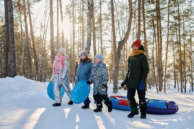 Des enfants marchent sur la route de la forêt.