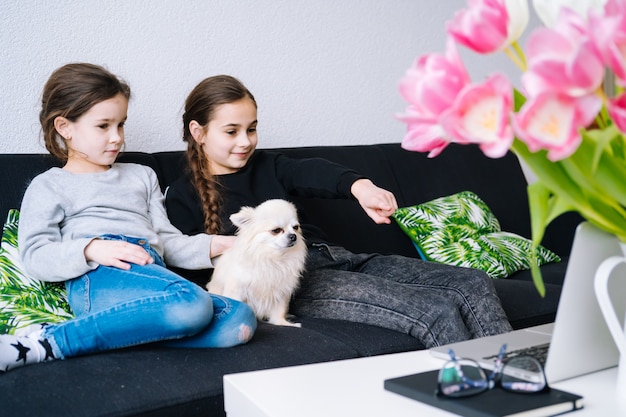 Enfants en masques médicaux étudiant leurs devoirs pendant une leçon en ligne à la maison