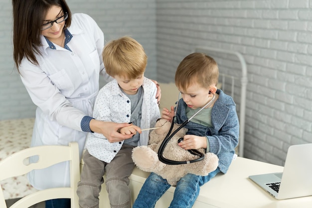 Les enfants médecins jouent avec un patient jouet