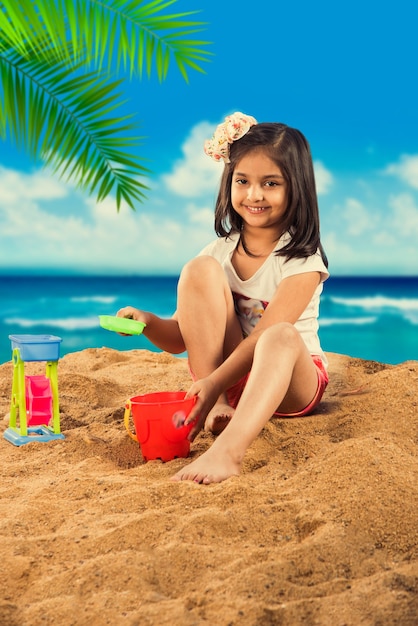 Enfants mignons asiatiques indiens jouant au sable de plage