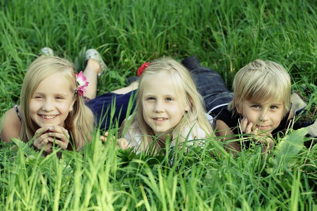 Enfants mignons à l'extérieur, enfants dans l'herbe d'été