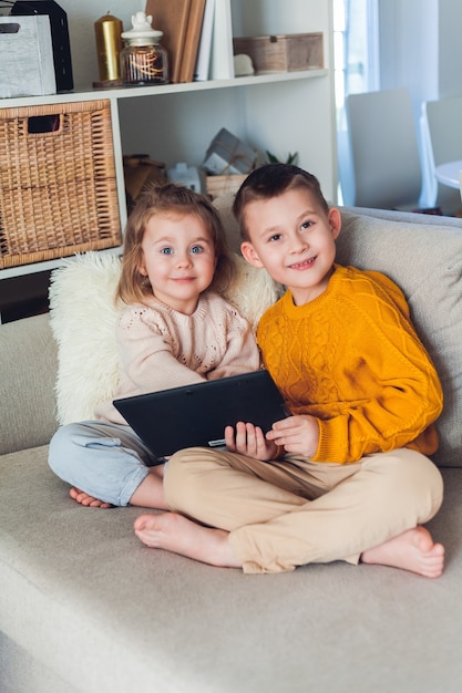 Des enfants mignons parlent par appel vidéo à l'aide d'une tablette. Quarantaine. Une famille. Accueil. Confortable.