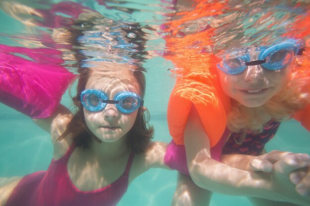 Enfants mignons posant sous l&#39;eau dans la piscine