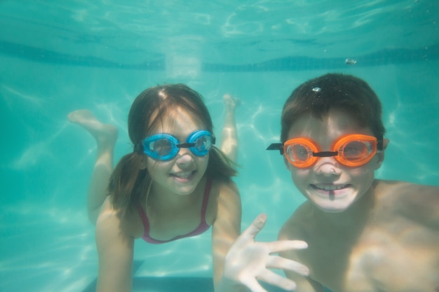 Enfants mignons posant sous l&#39;eau dans la piscine