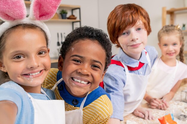 Photo enfants multiethniques heureux dans la cuisine