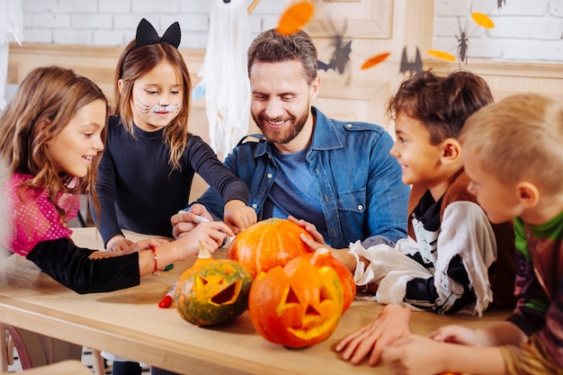 Enfants et neveux. Homme rayonnant invitant ses enfants et ses neveux pour une incroyable fête d'Halloween mémorable