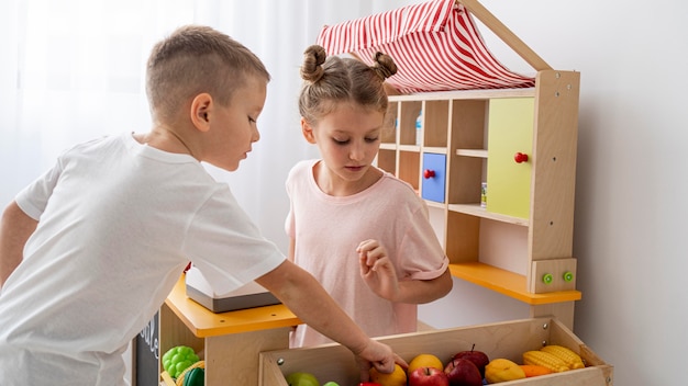 Photo enfants non binaires jouant ensemble à l'intérieur