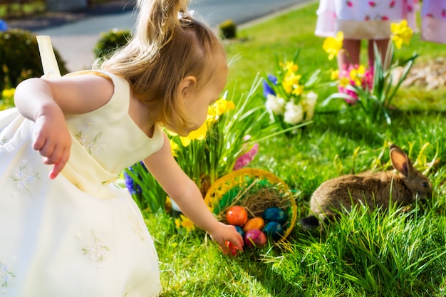 Enfants sur un oeuf de Pâques avec un lapin