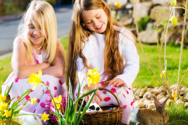 Enfants sur un oeuf de Pâques avec un lapin