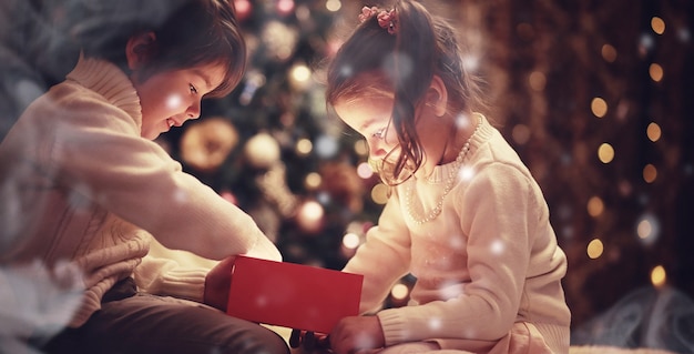 Enfants ouvrant des cadeaux de Noël Enfants sous l'arbre de Noël avec des coffrets cadeaux