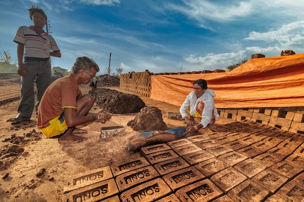 Enfants d'ouvriers aidant à fabriquer des briques traditionnelles à la main dans le four à briques ou l'usine.