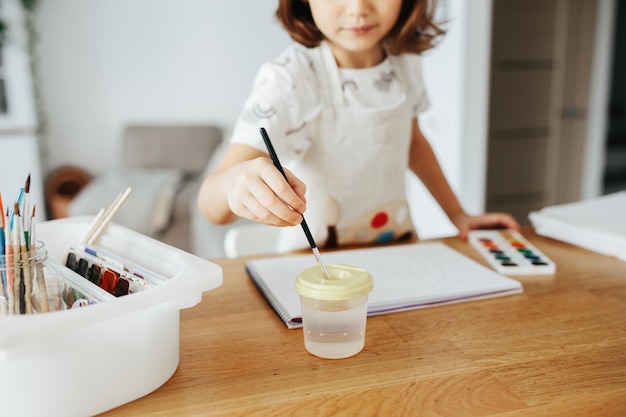 Enfants peignant des arcs-en-ciel aquarelles à table à la maison