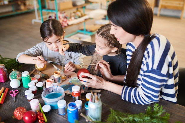 Enfants peignant des ornements de Noël