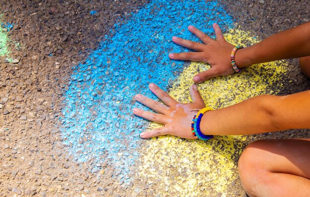 Les enfants peignent un arc-en-ciel sur l'asphalte Mise au point sélective