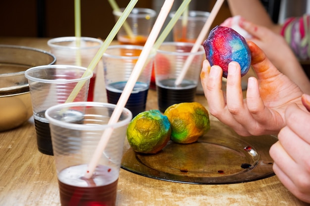 Photo les enfants peignent des œufs de pâques avec des colorants colorés d'une manière inhabituelle