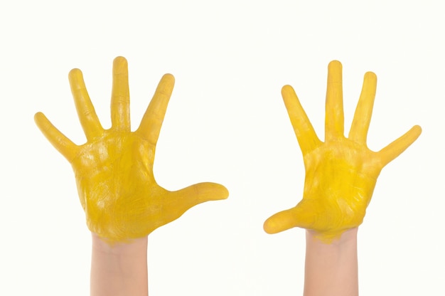 Un enfants peint dans un jaune mains isolés