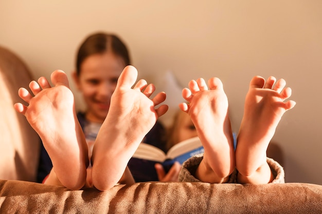 Enfants pieds nus à la maison Les enfants Sœurs s'amusent à jouer avec leurs pieds Mise au point sélective Happ