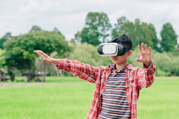 Enfants portant des lunettes vidéo de réalité virtuelle et joyeux dans un beau fond de nature