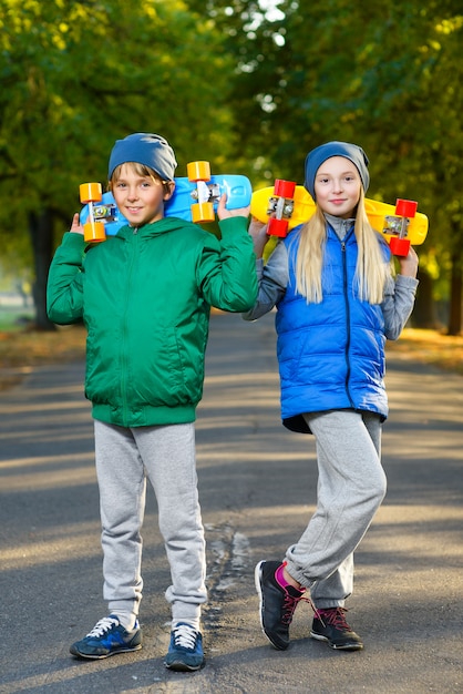 Enfants posant avec planche à roulettes à l'extérieur