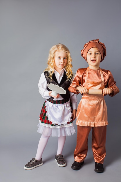 Les enfants posent dans les costumes d'un serveur et d'un cuisinier